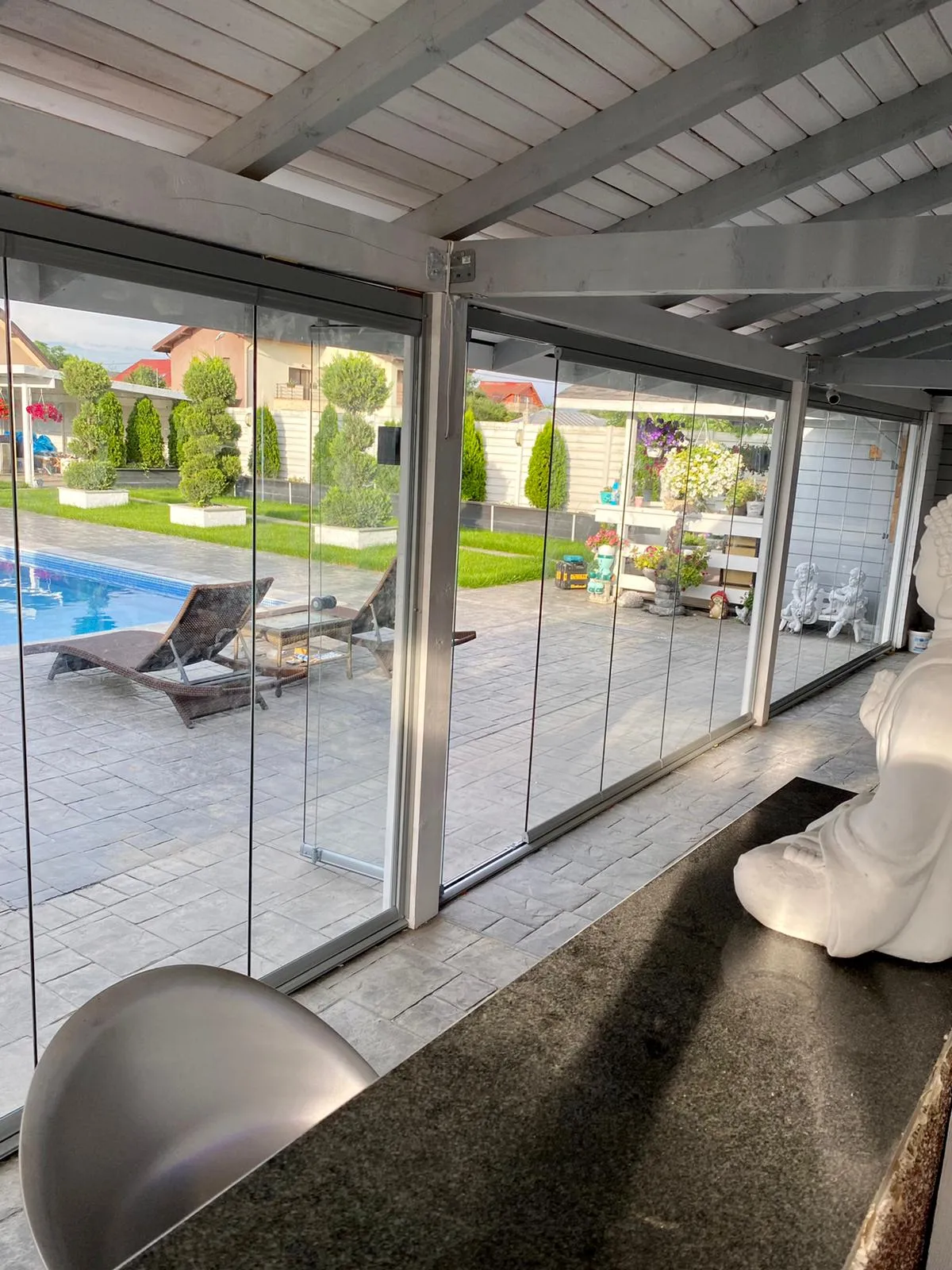 Terasă acoperită închisă cu sistem glisant din sticlă, lângă piscină